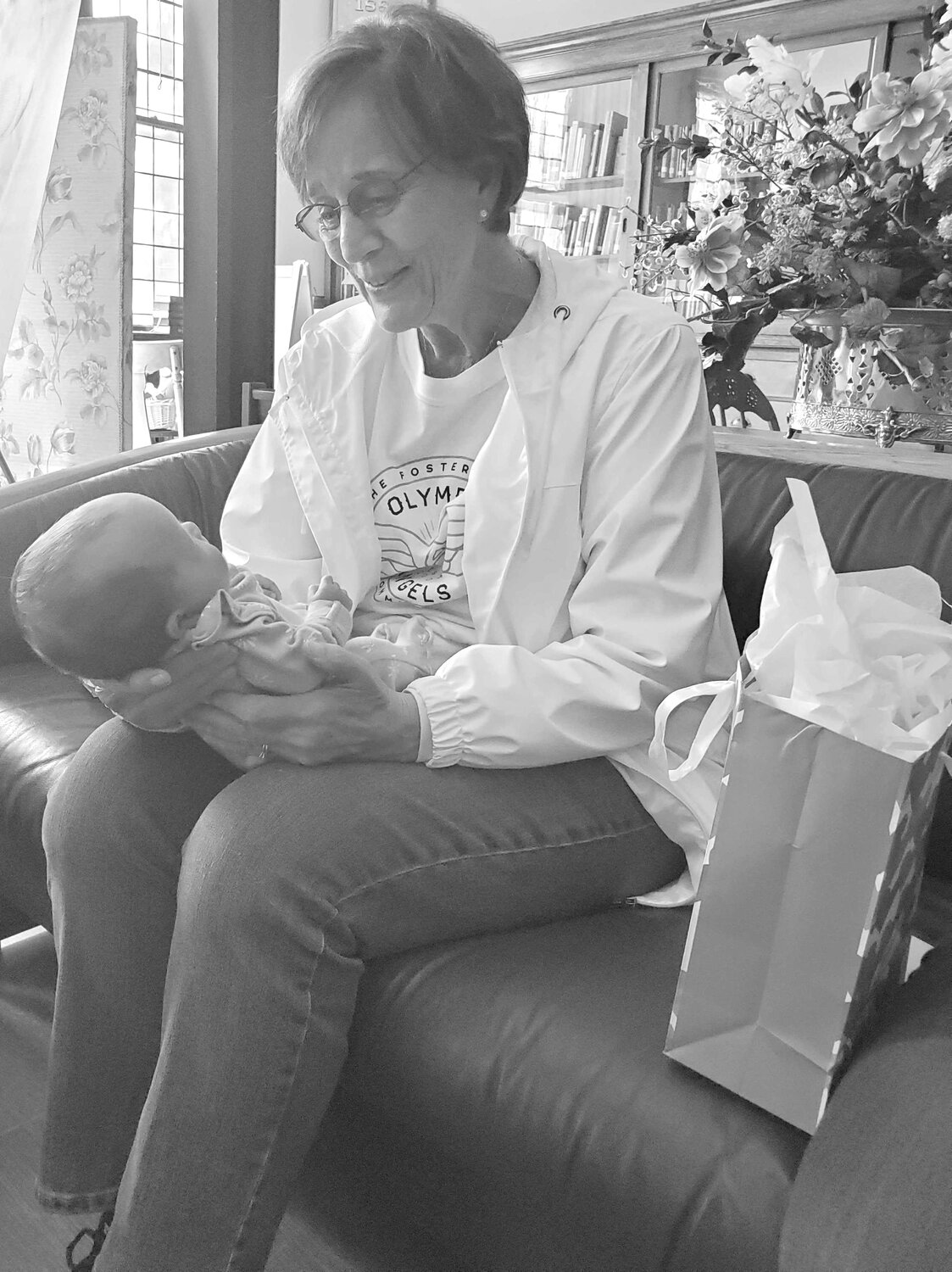Olympic Angels Love Box volunteer Jenny Vervynck helps single foster caregiver care for an infant.